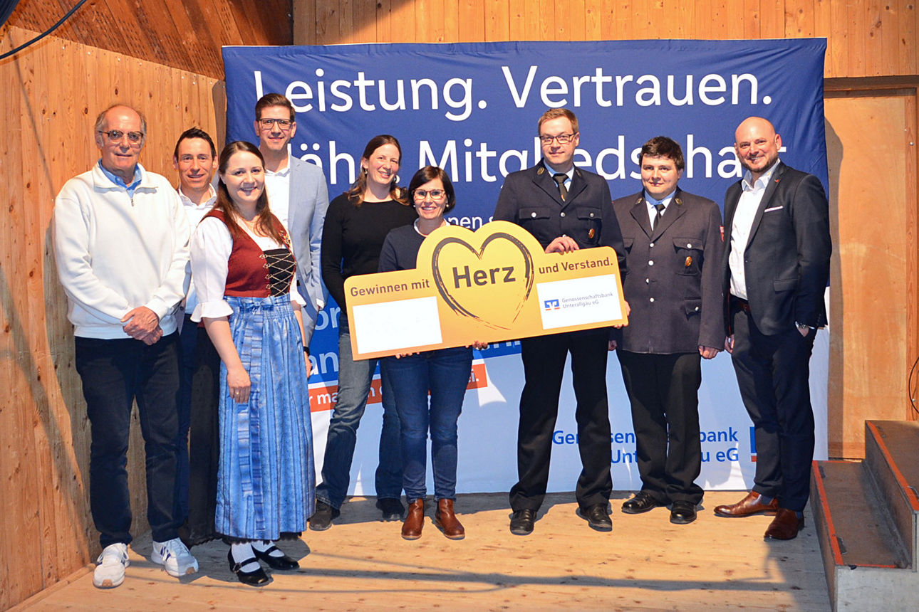 Spendenempfänger stehen mit großem Spendenscheck nebeneinander