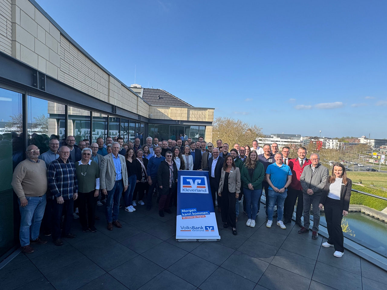 Gruppenfoto auf der Dachterrasse der Volksbank Kleverland mit den Vereinen die ihm Rahmen der Förderung untestützt wurden