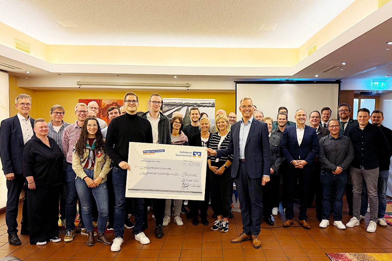 Vereinsvertreter und Vorstand Bernd Griese posieren mit Riesenscheck bei der Preisverleihung.
