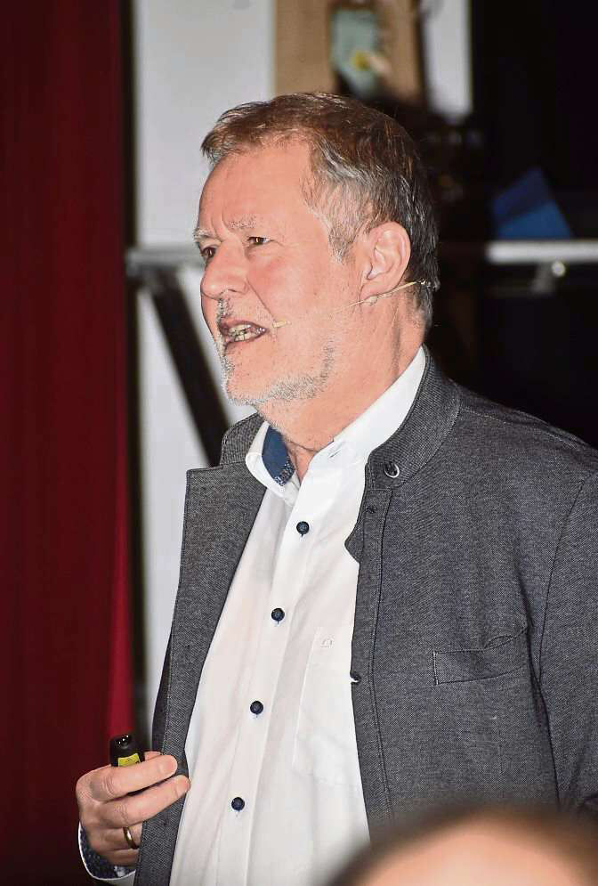 Ein Mann mit Mikrofon und Pointer hält einen Vortrag