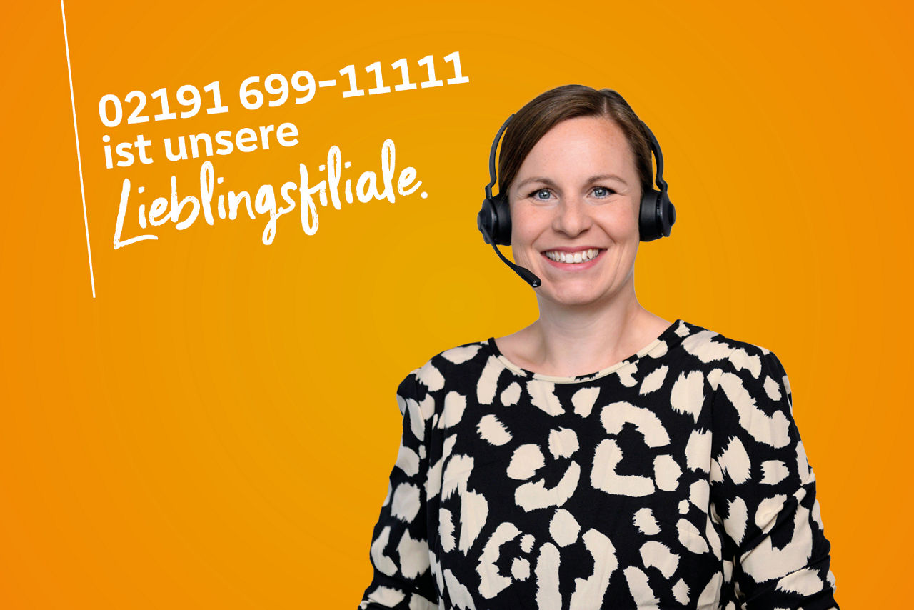 Kollegin im gemusterten Oberteil trägt Headset und strahlt