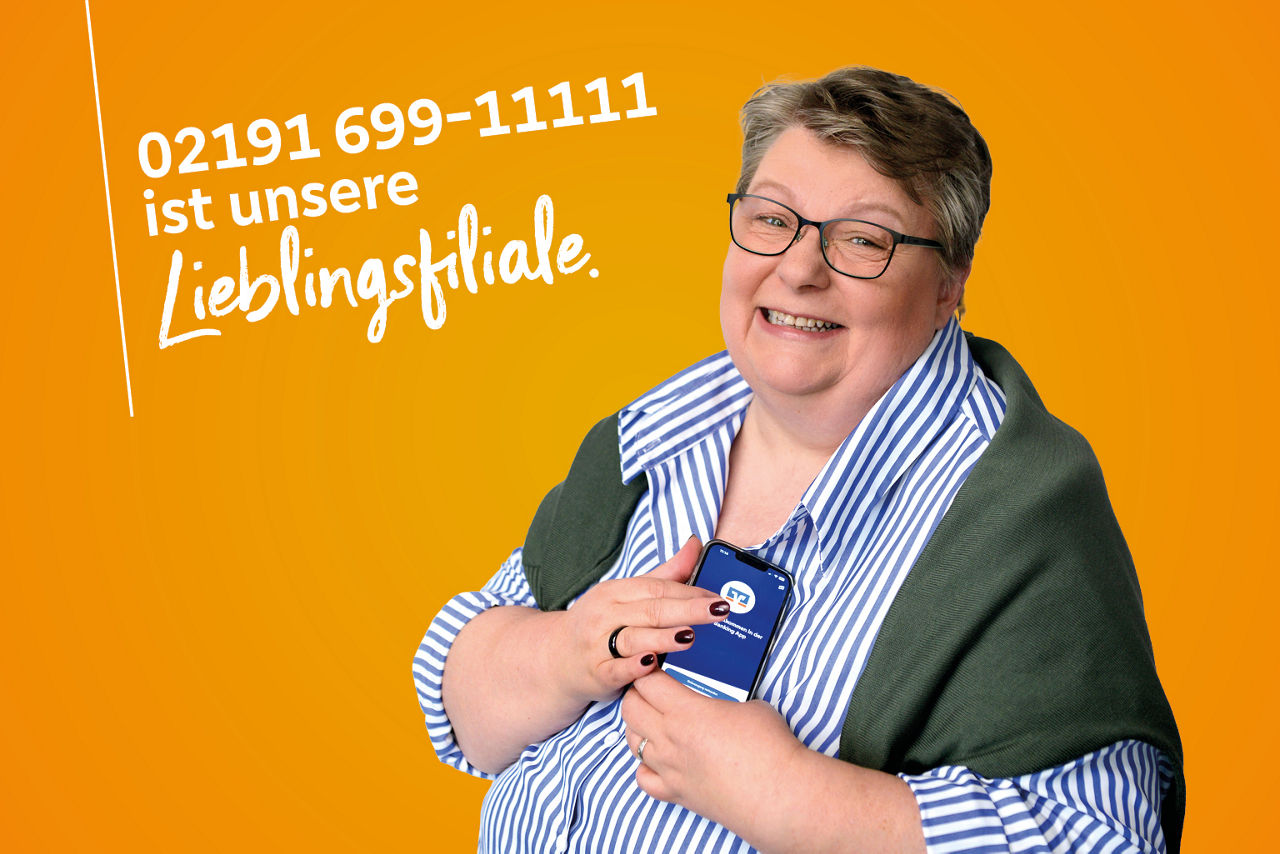 Kollegin in blauer Bluse hält Handy mit OnlineBanking-App 