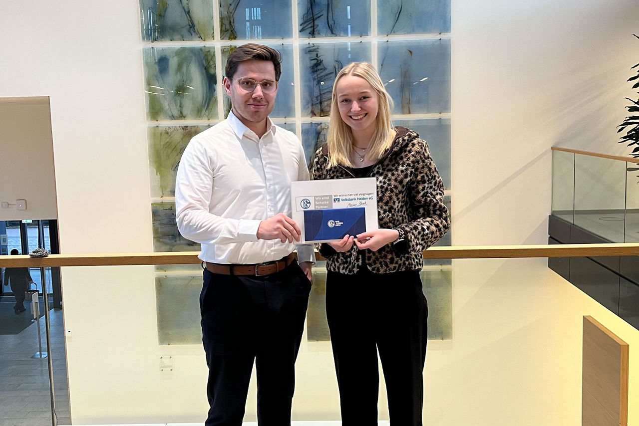 Ein Mann und eine Frau stehen zusammen vor einem großen Fenster, wobei natürliches Licht ihre Umgebung erhellt