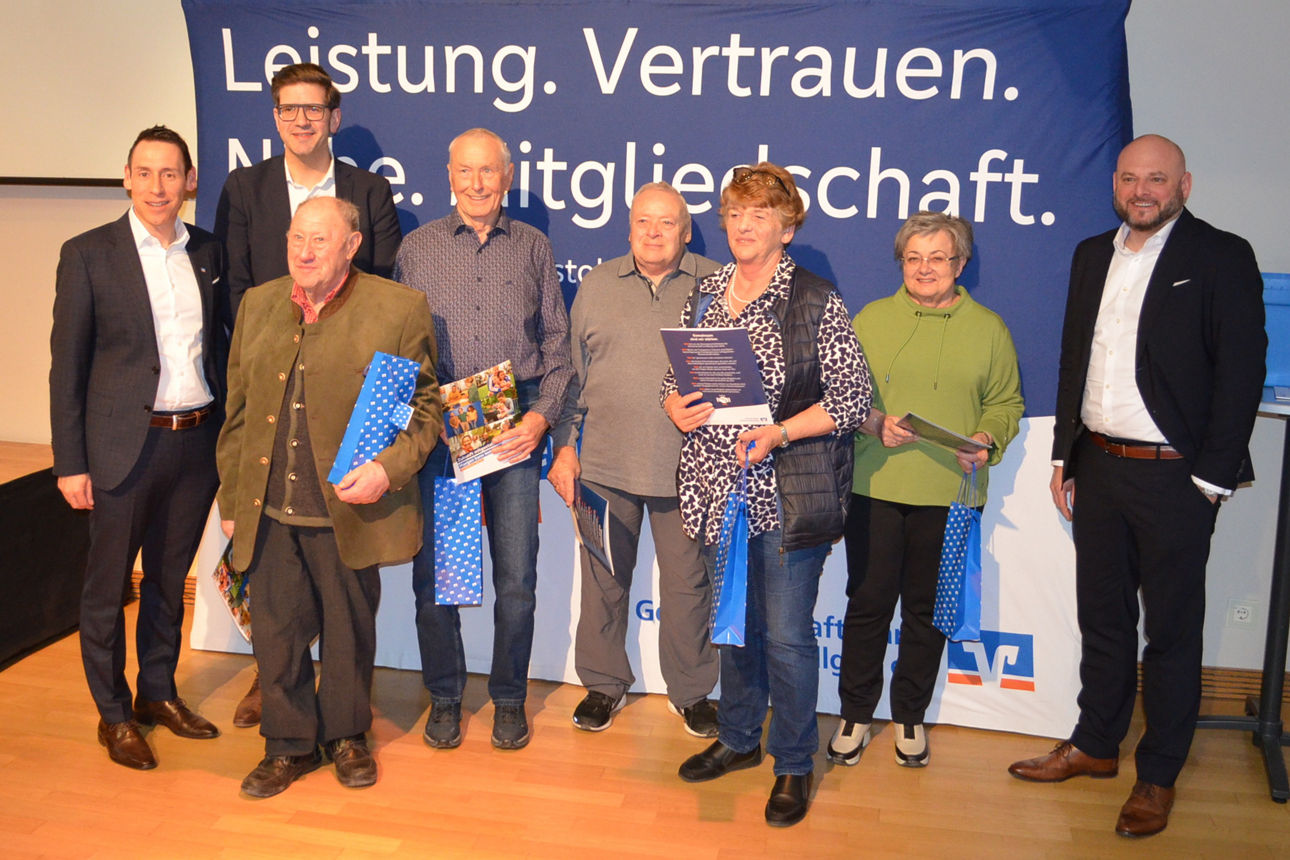 Geehrte Personen stehen nebeneinander vor einer Wand