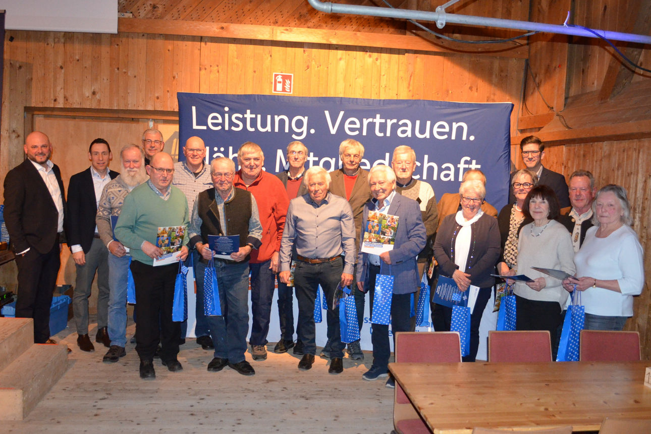 Viele geehrten Personen stehen vor einer Holzwand