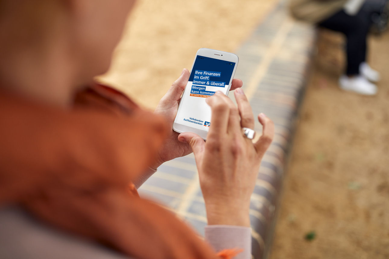 Eine Frau hat auf einem Handy die VR-Banking App geöffnet.