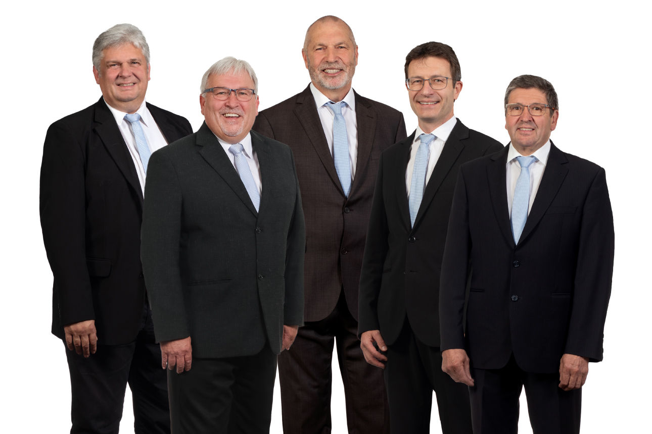 Fünf Männer in Anzügen lächeln in die Kamera