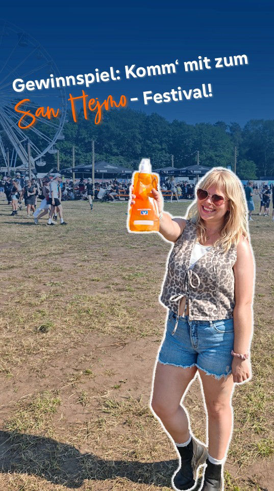 Eine junge Frau ist auf einem Festival und hält Volksbank Flasche in die Kamera