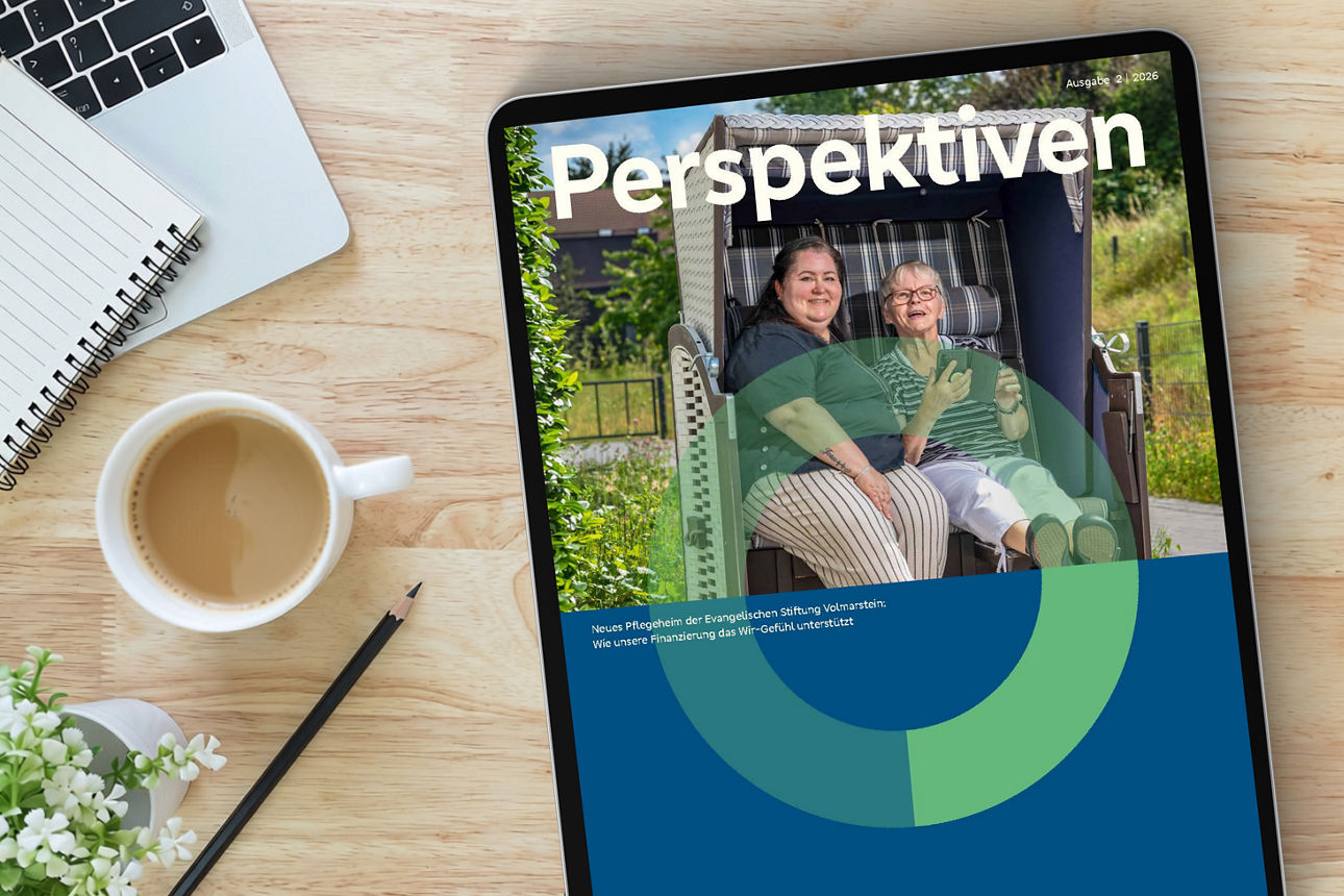 Neue Ausgabe des Online-Magzins auf Tablet liegt auf Tisch neben Kaffetasse, Stift und Laptop