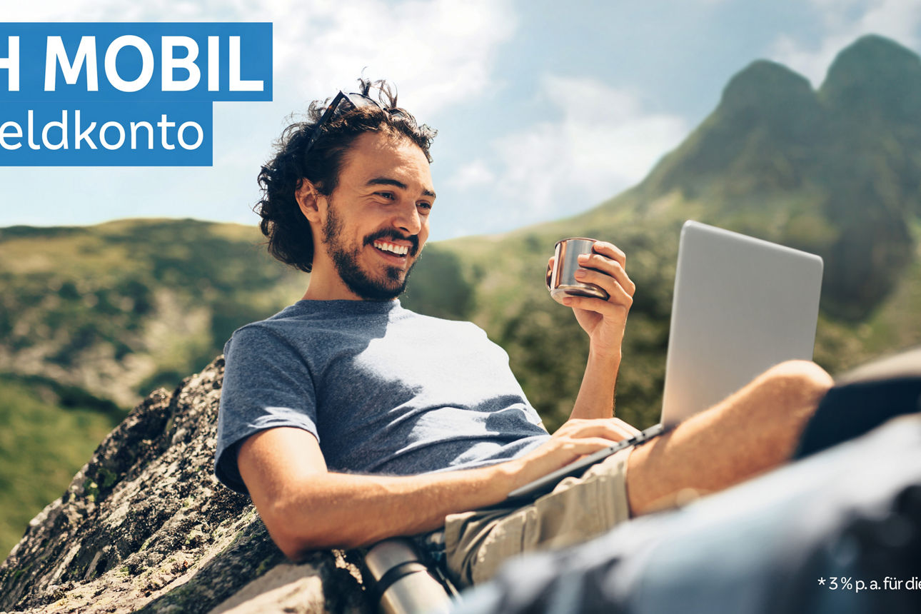 Man sitzt auf einem Berg mit seinem Laptop