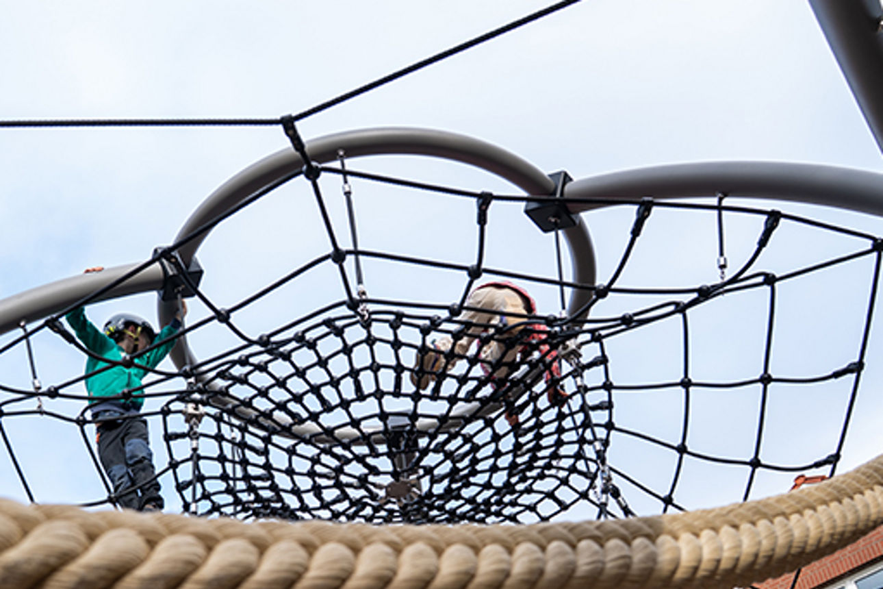 Aufnahme von unten in den Himmel durch die Netze der Kletterpyramide