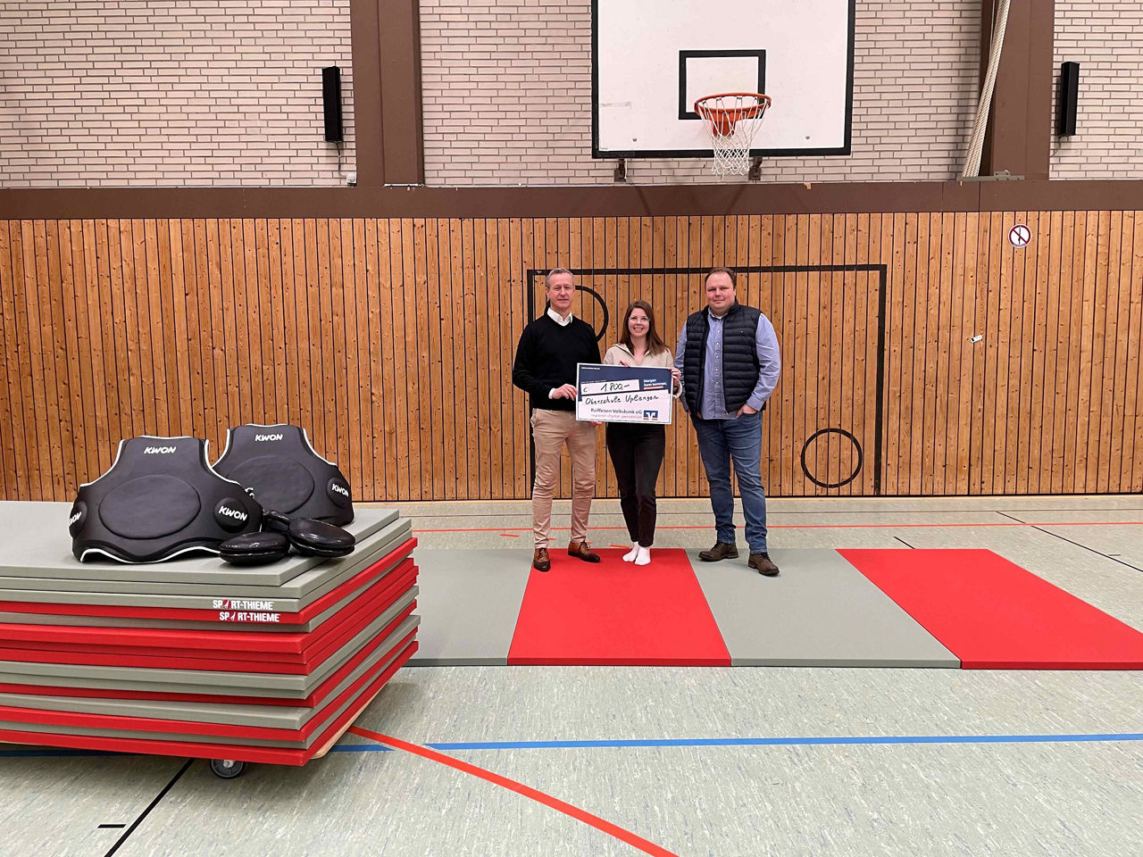 Spendenübergabe in einer Sporthalle