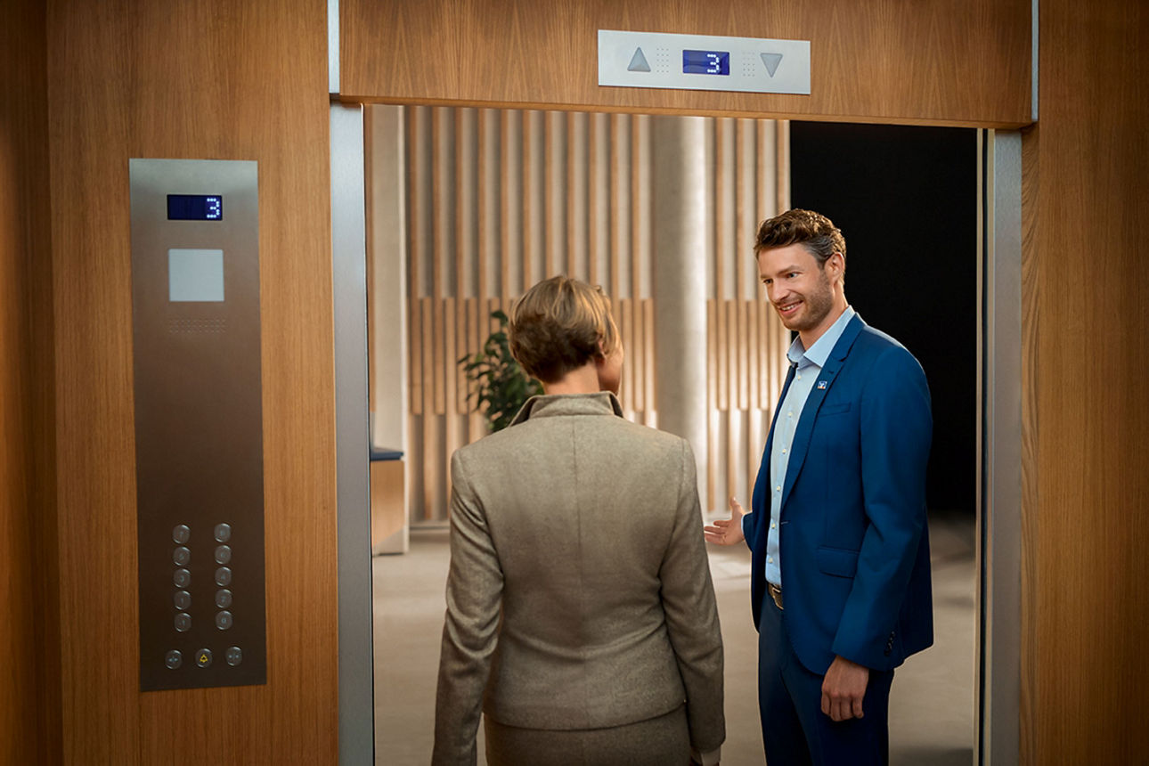 Zwei Personen treten aus einem Aufzug