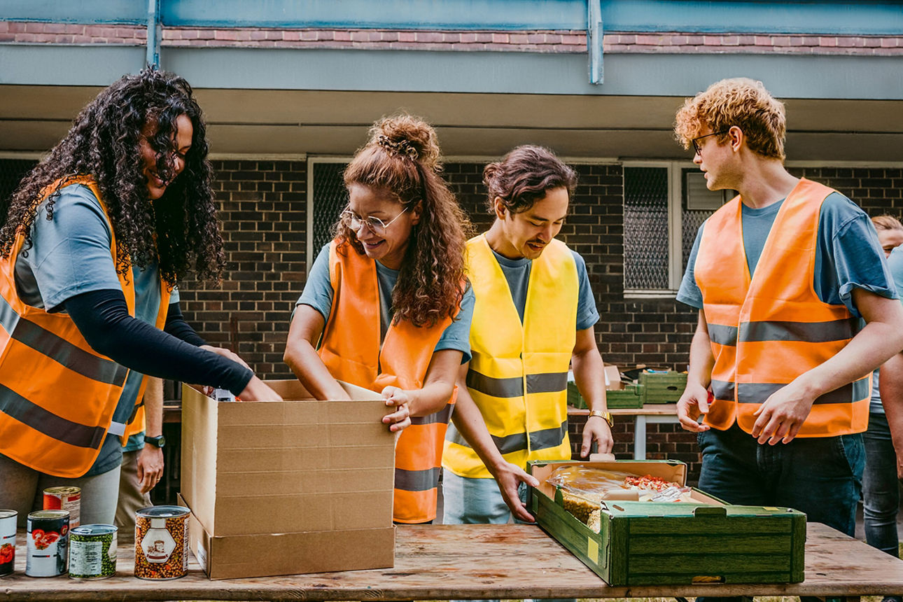 Vier Personen in Warnwesten organisieren Kartons