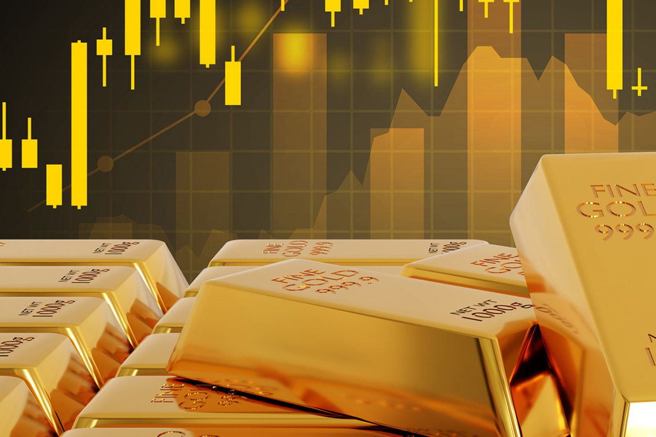 Goldbarren aufeinandergestapelt mit Kursverlauf-Grafik im Hintergrund