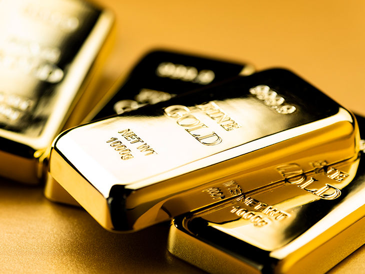 Goldbarren auf goldenem Hintergrund liegend