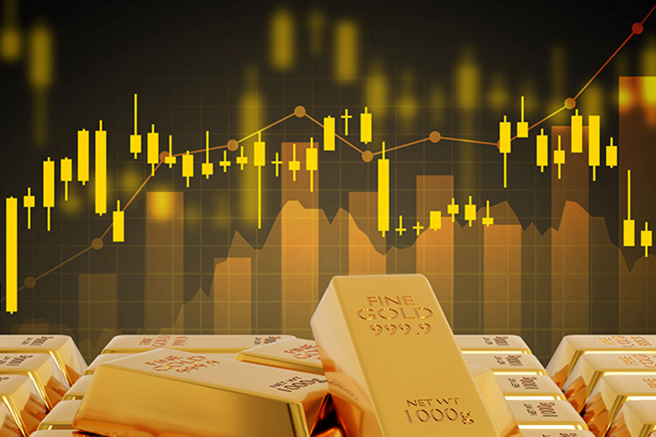 Goldbarren aufeinandergestapelt mit Kursverlauf-Grafik im Hintergrund