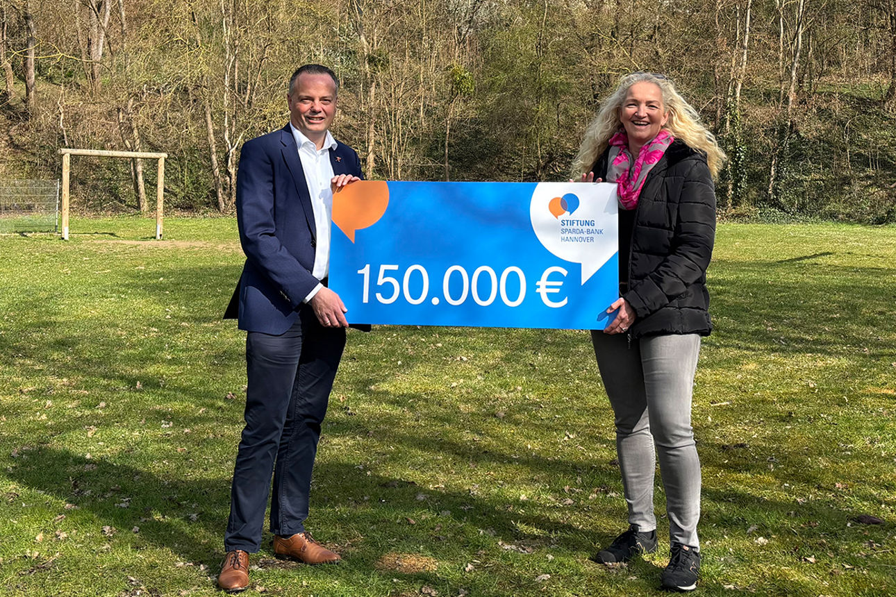 Symbolische Scheckübergabe auf einer Grünfläche