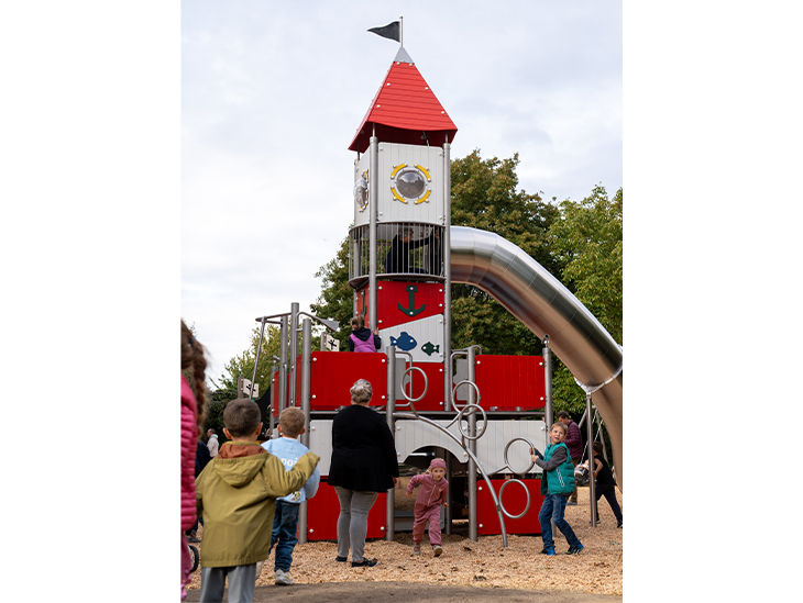 Rot-weißer Leuchtturm mit Röhrenrutsche auf Sandspielplatz in Gehrden