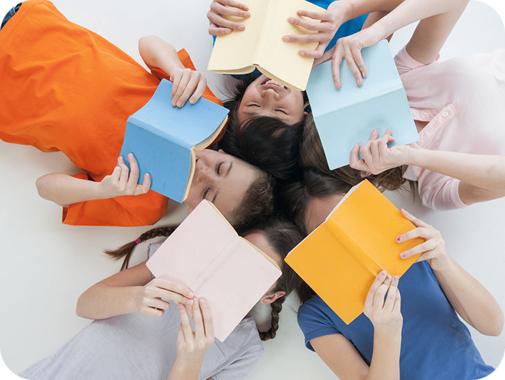 Jugendliche lesen auf dem Rücken liegend Bücher