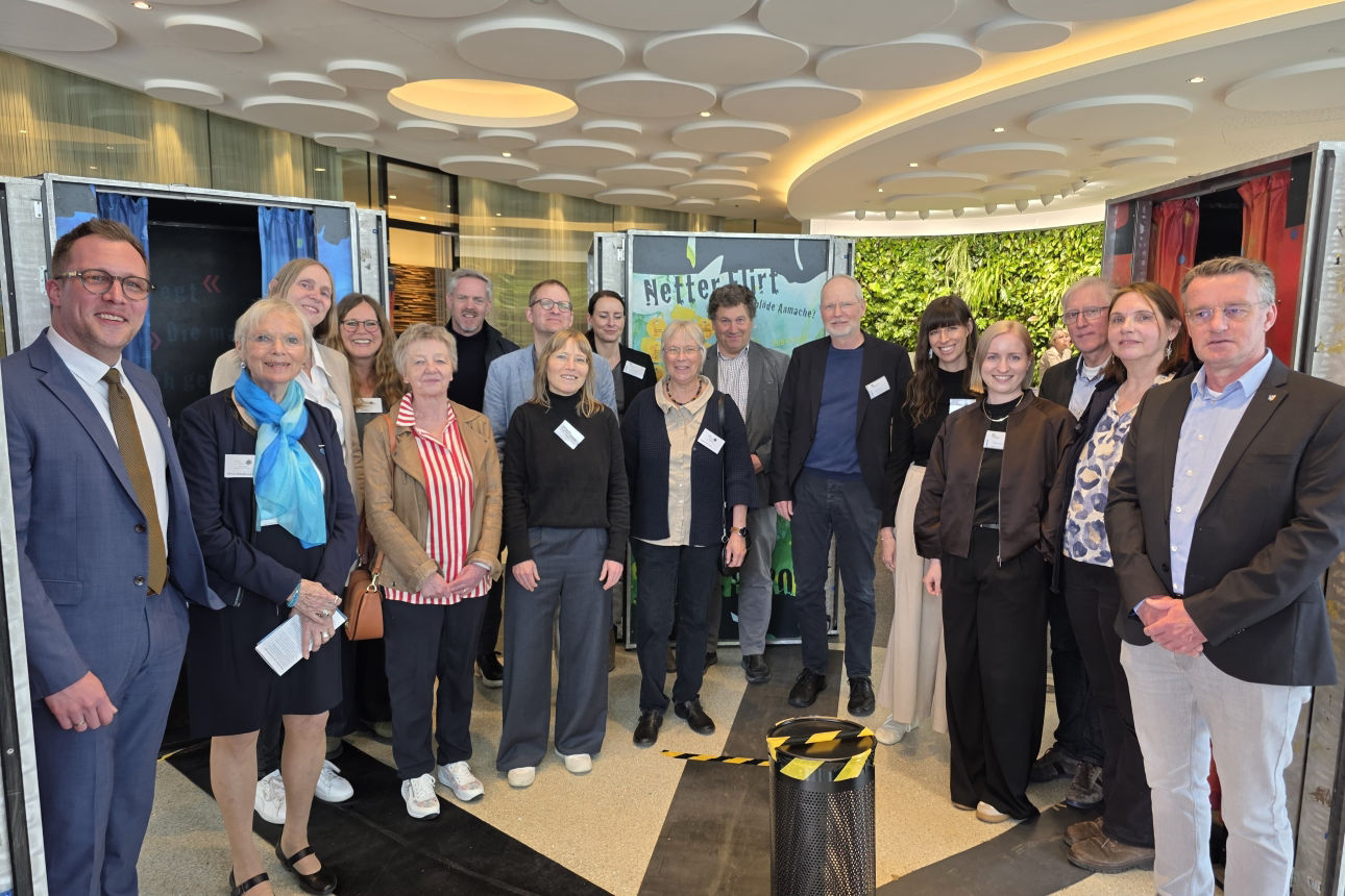 Mehrere Vertreterinnen und Vertreter von Beratungsstellen, Politik und Volksbank Oberberg stehen im Foyer der Volksbank Oberberg und eröffnen die Ausstellung „Echt krass!“ zum Thema Prävention sexualisierter Gewalt.