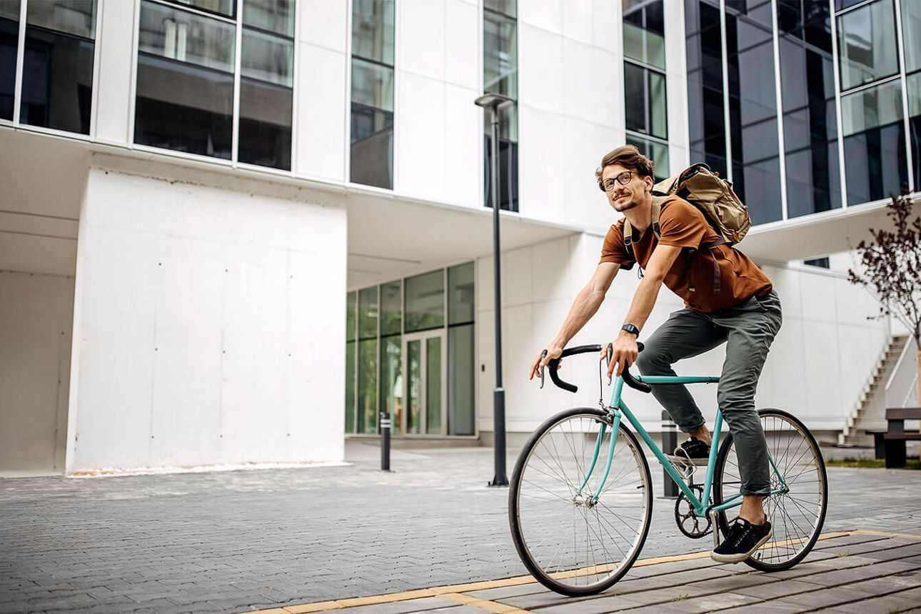 Junger Mann fährt mit dem Rennrad zur Arbeit