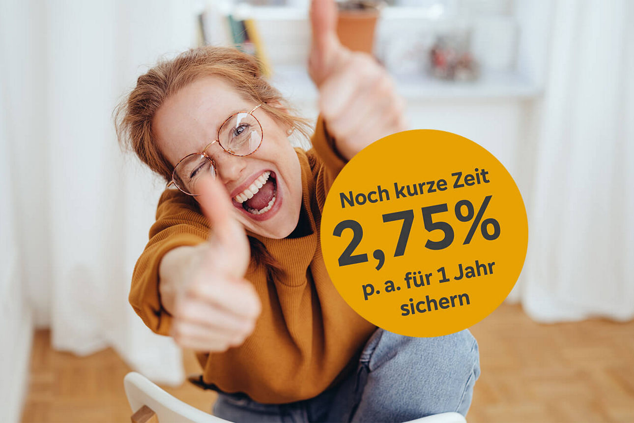 Junge Frau mit Brille zeigt zwei Daumen hoch und freut sich über das Festgeld