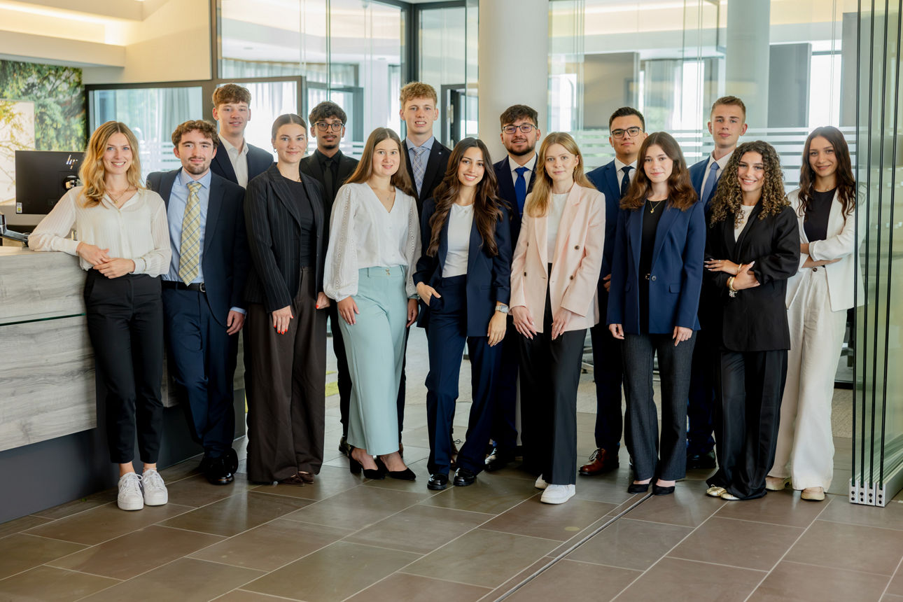 14 neue Auszubildende der Volksbank Oberberg stehen gemeinsam mit Ausbildungsleiterin Sarina Scherbaum in der Hauptstelle in Wiehl. Die Gruppe lächelt in die Kamera und markiert den gemeinsamen Start in die Ausbildung zum 1. August 2026.