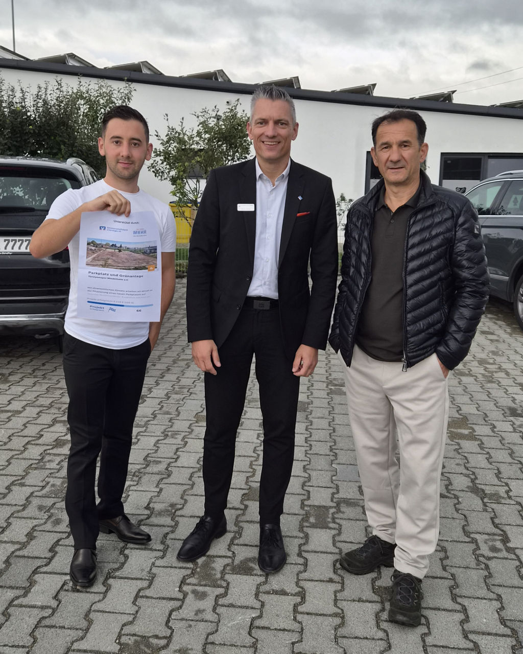 Gruppe an Personen stehen vor einer Gartenhütte