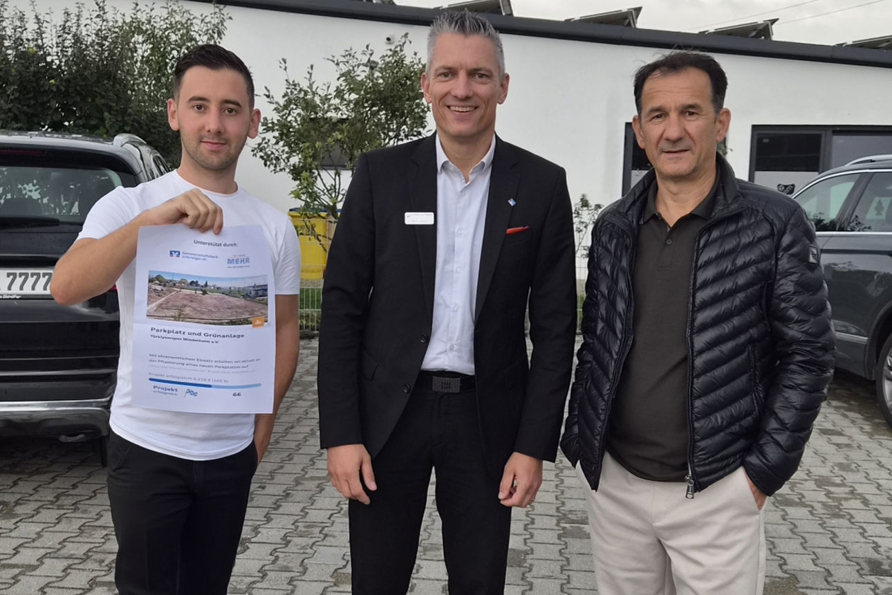 Einer von drei Männern zeigt ein Dokument 
