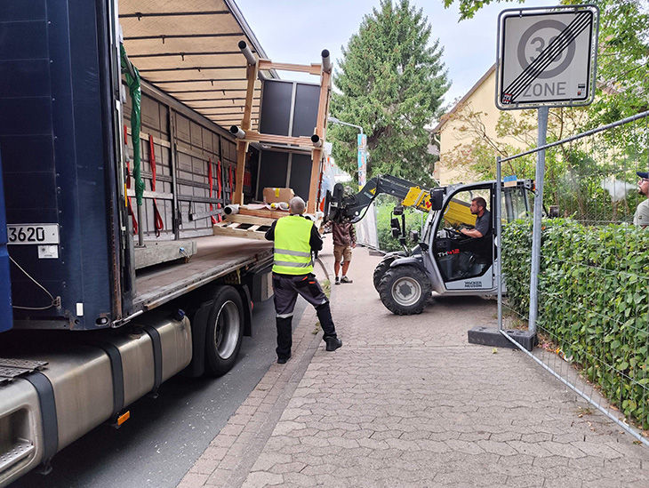 Spielgeräte werden mithilfe eines Gabelstaplers von einem Lastwagen geladen. 