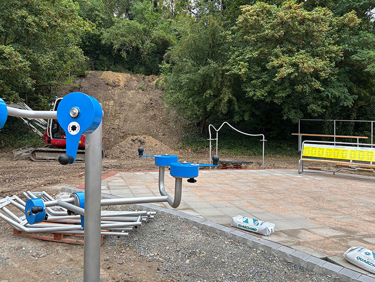 Die Bauteile liegen zur Montage bereit. Neu gepflasterte Fläche mit Platz für eine spezielle Fitnessbank.