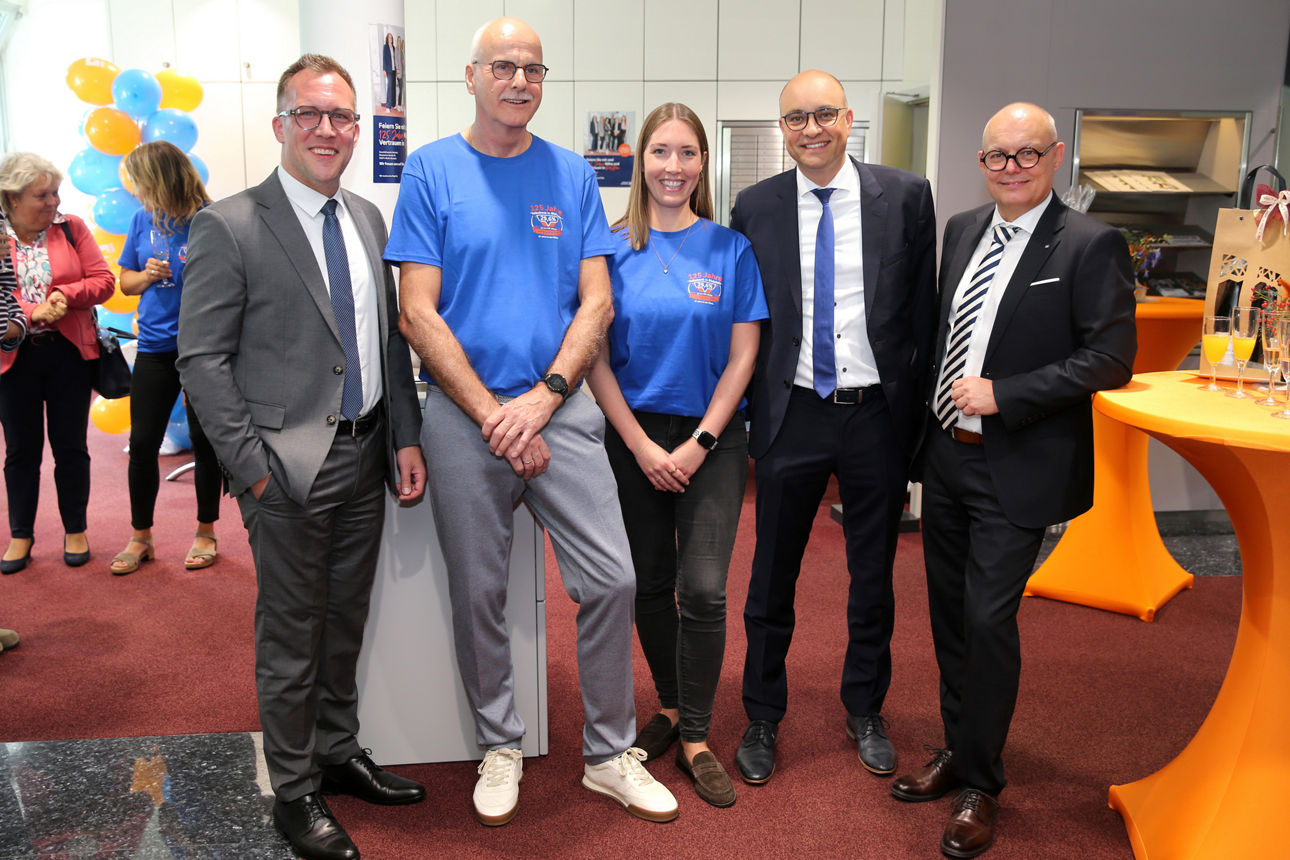 Die Vorstände Andreas Neumann, Marc Gottschlich und Jörn Richling stehen mit dem bisherigen Geschäftsstellenleiter Harry Faßbender und seiner Nachfolgerin Ann-Kathrin Miebach in der Geschäftsstelle Bielstein.