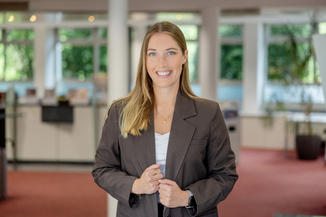 Ann-Kathrin Miebach steht in den Räumen der Volksbank Oberberg und blickt in die Kamera. Die neue Leiterin der Geschäftsstelle Bielstein trägt einen dunklen Blazer und ein helles Oberteil.