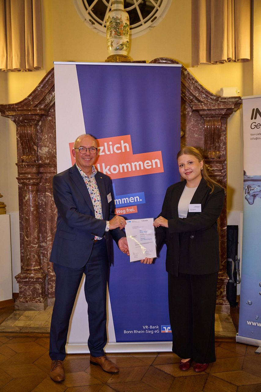 Das Bild zeigt Markus Neuber und die Absolventin Anna Dudenkova mit der Förderpreisurkunde.