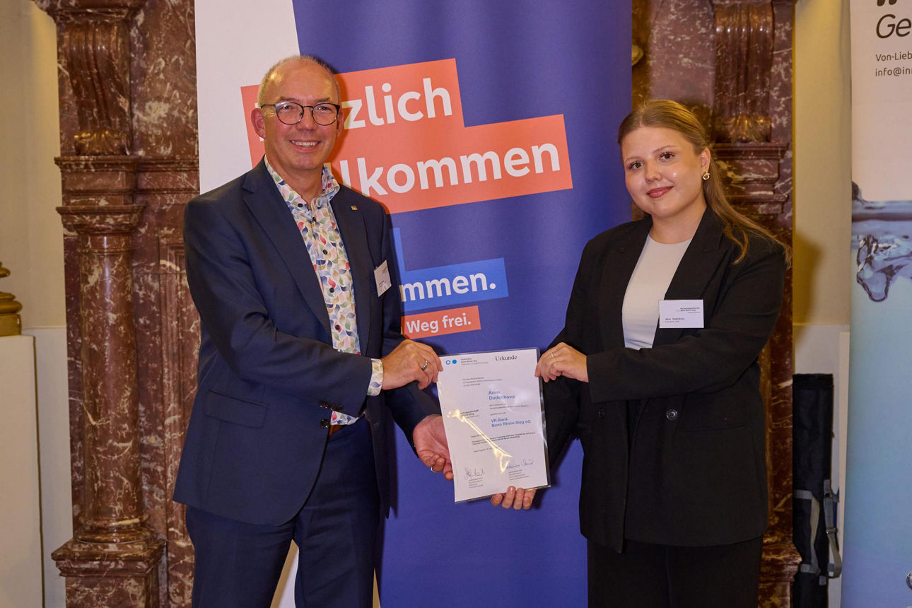 Das Bild zeigt Markus Neuber und die Absolventin Anna Dudenkova mit der Förderpreisurkunde.