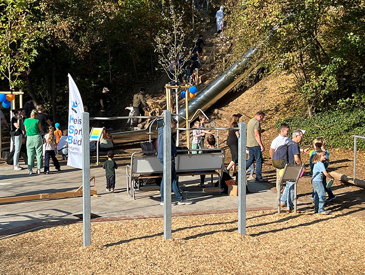 Blick auf einen Teil des Geländes vom Traumspielpark. Zu sehen sind ein doppeltes Turnreck, eine Fitnessbank und eine Röhrenr