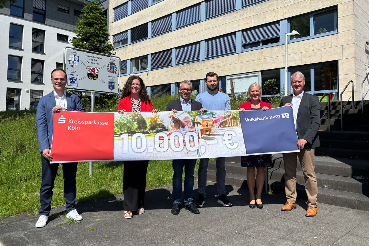 Helmut Vilmar (Volksbank Berg) und Mitarbeiter der Kreissparkasse Köln übergeben 10.000€ für den Waldspielplatz in Lindlar