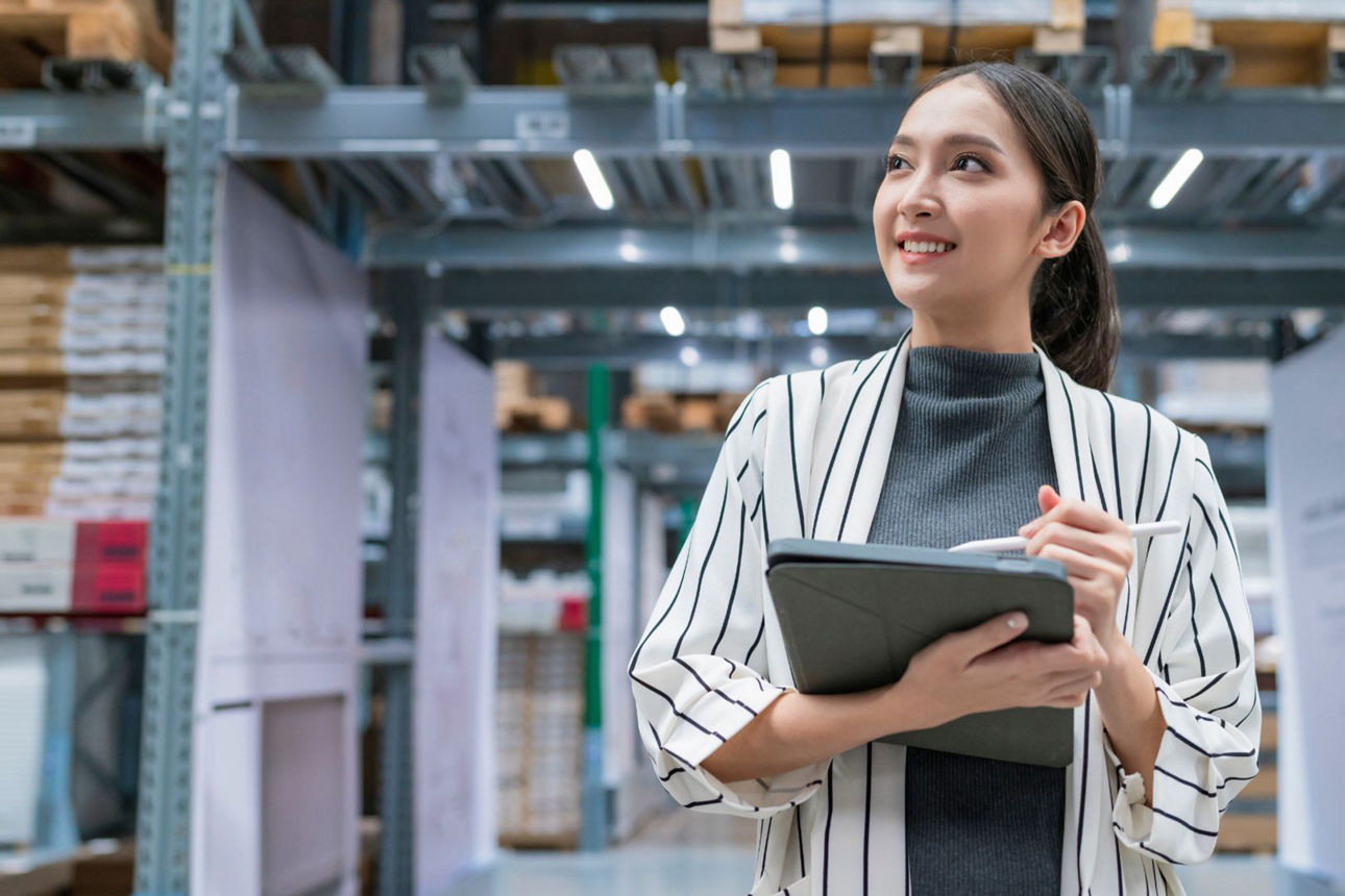 Unternehmerin mit Notebook in Industriehalle