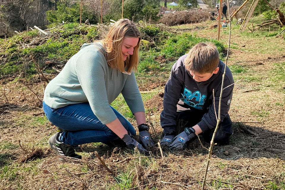 Mutter und Sohn beim pflanzen eines Baums