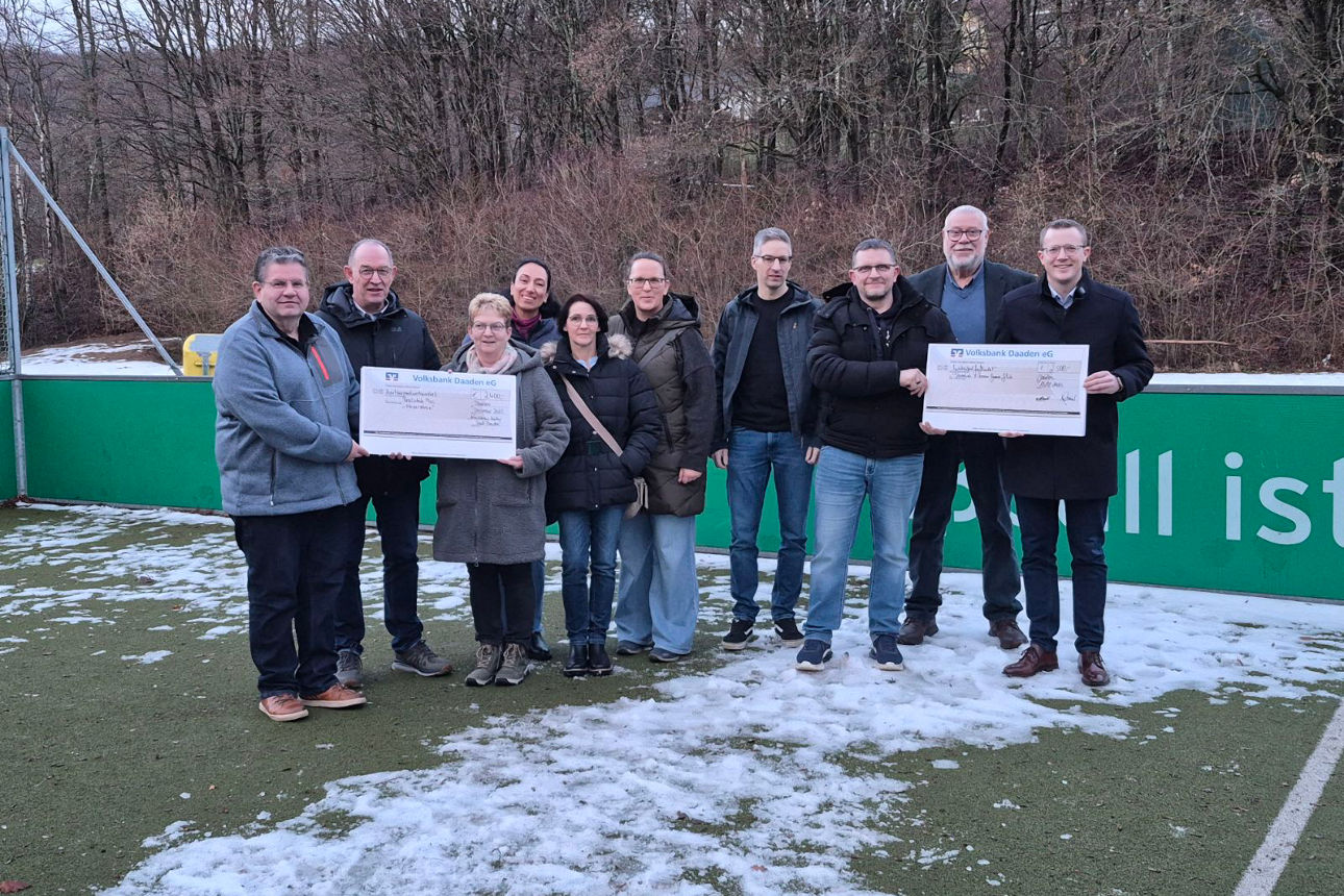 Eine Personengruppe bei einer Spendenübergabe auf dem Soccerfeld