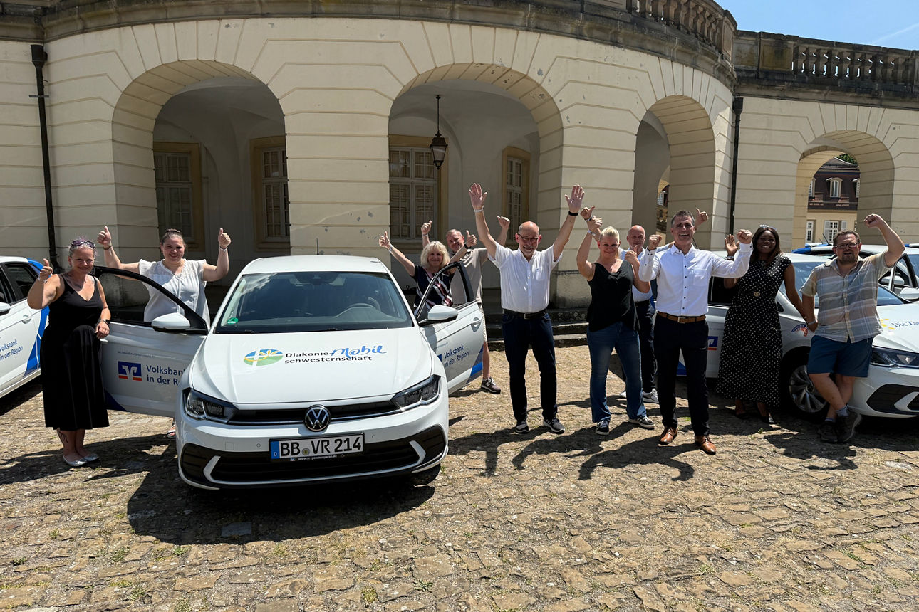 Jubelnde Menschen stehen vor einem VRmobil vor Schloss Solitude