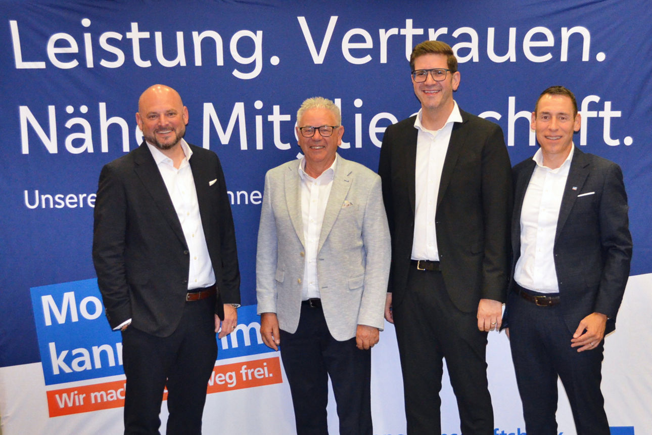 Vier Personen stehen vor einer Leinwand