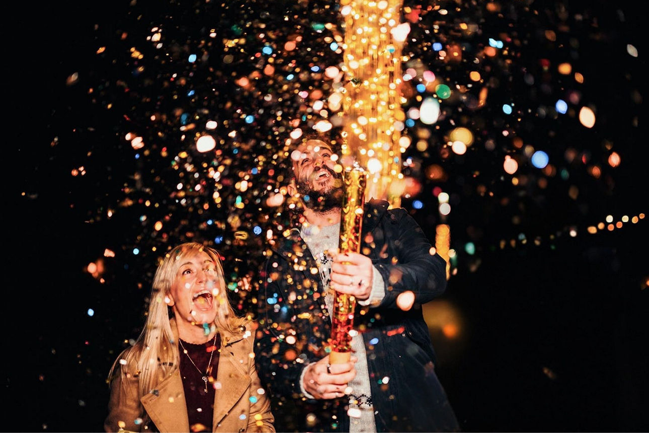 Eine Frau und ein Mann freuen sich über funkelndes Feuerwerk
