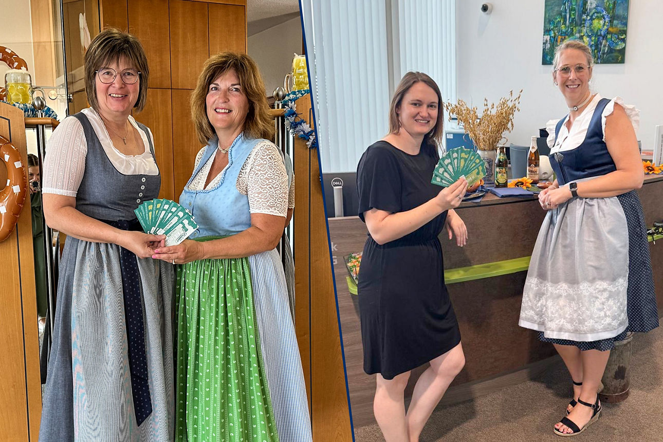 Zwei Frauen in traditionellen Dirndl-Outfits, die bei einer Veranstaltung Eintrittskarten in der Hand halten.