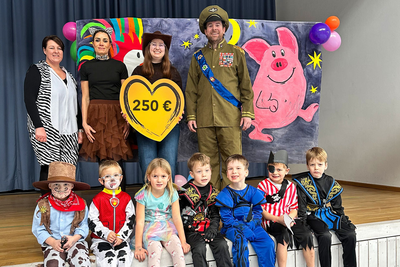 Gruppenfoto mit mehreren Erwachsenen und Kindern in Kostümen