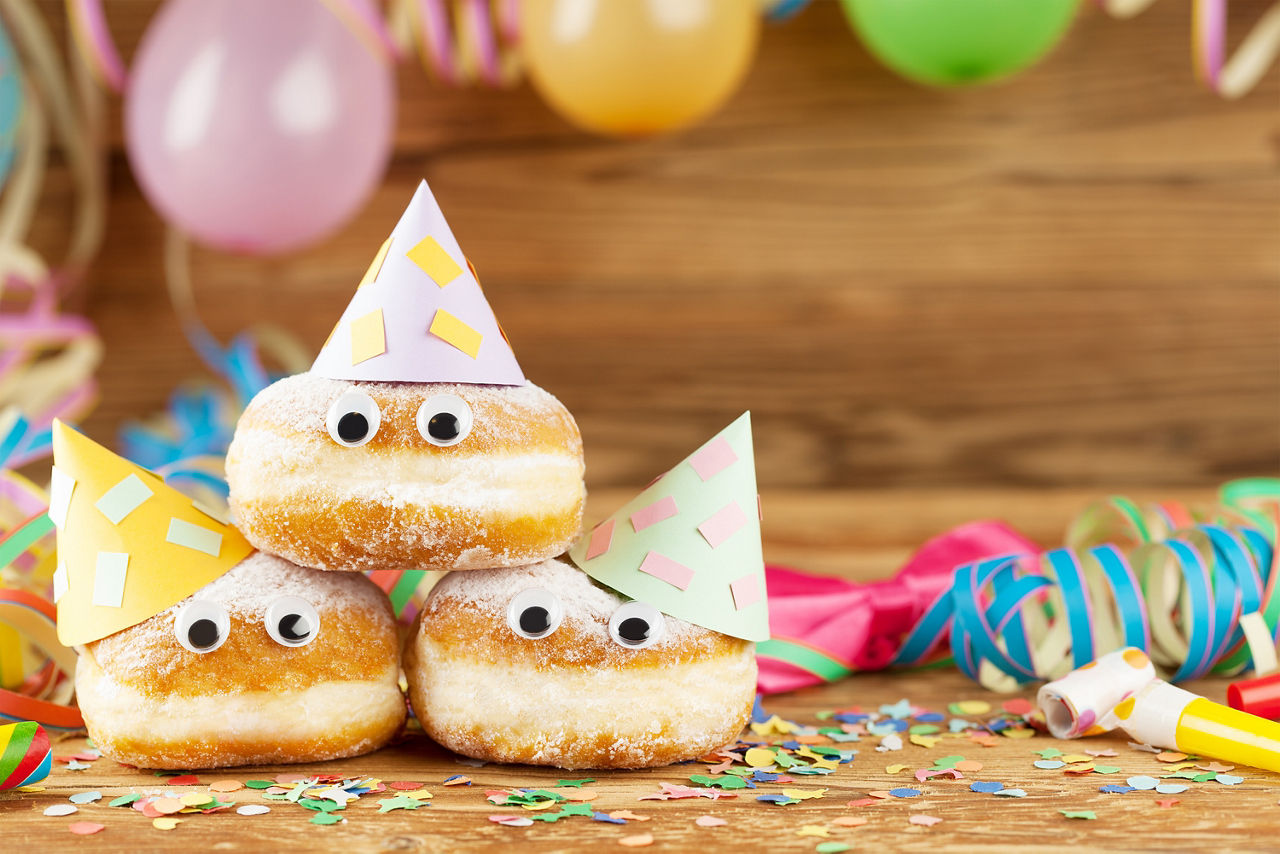 Festliches Arrangement aus gepuderten Donuts, verziert für eine Feier