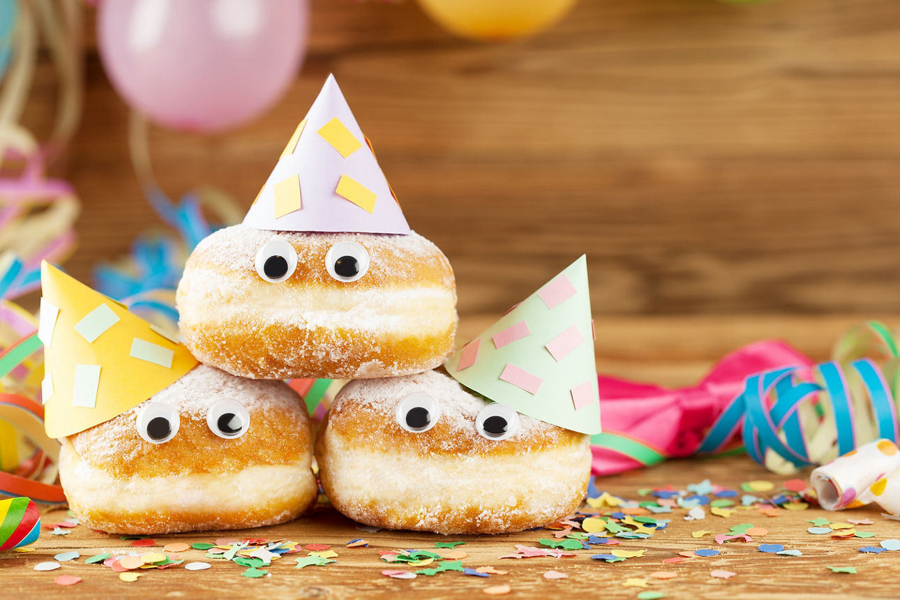 Festliches Arrangement aus gepuderten Donuts, verziert für eine Feier