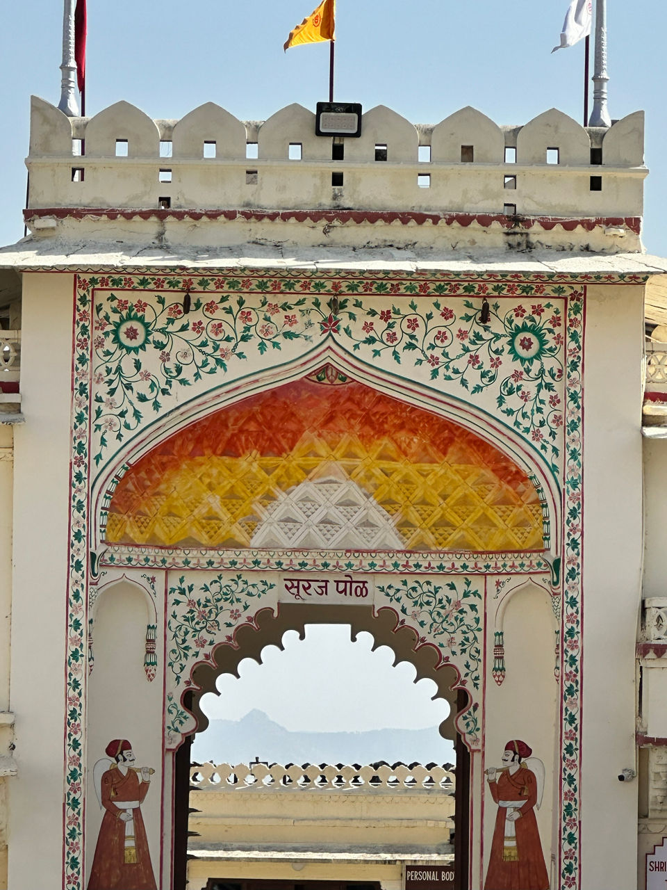 Ein weißes Gebäude mit einem lebendigen, farbenfrohen Torbogen, der einen auffälligen Kontrast zur Fassade bildet