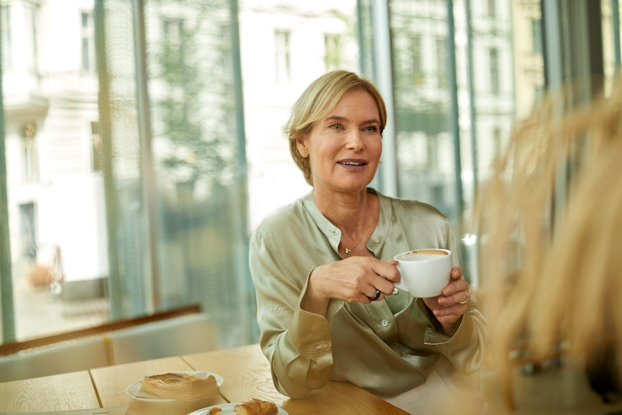Ältere Frau mit Kaffee in der Hand